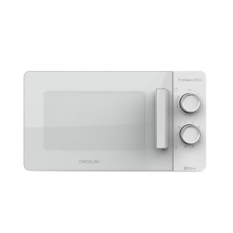 Micro-ondes blanc à porte claire et commandes rotatives, posé sur un plan de travail en bois clair.