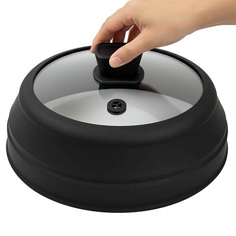 Cloche pliable en silicone noir avec hublot en verre trempé posée sur une assiette