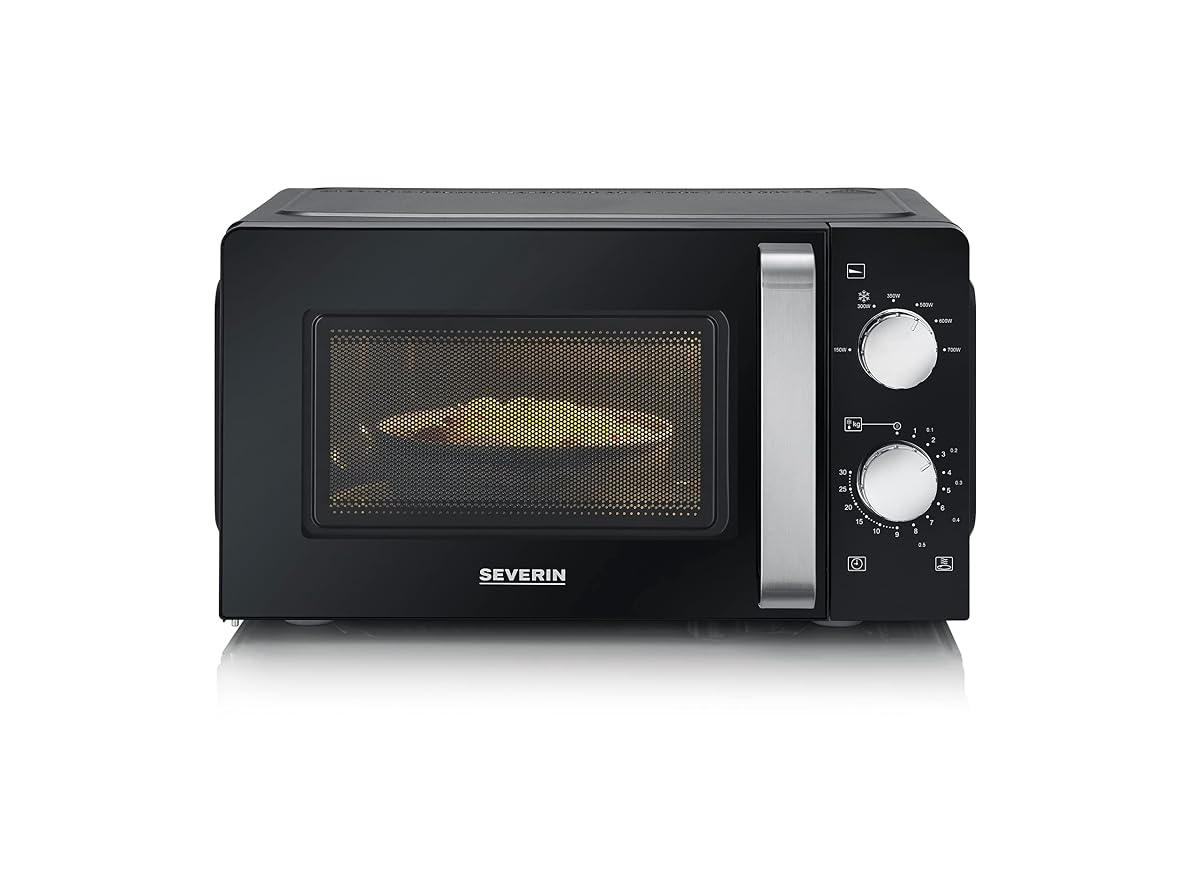 Micro-ondes solo noir compact avec commandes rotatives et plateau tournant sur un plan de travail